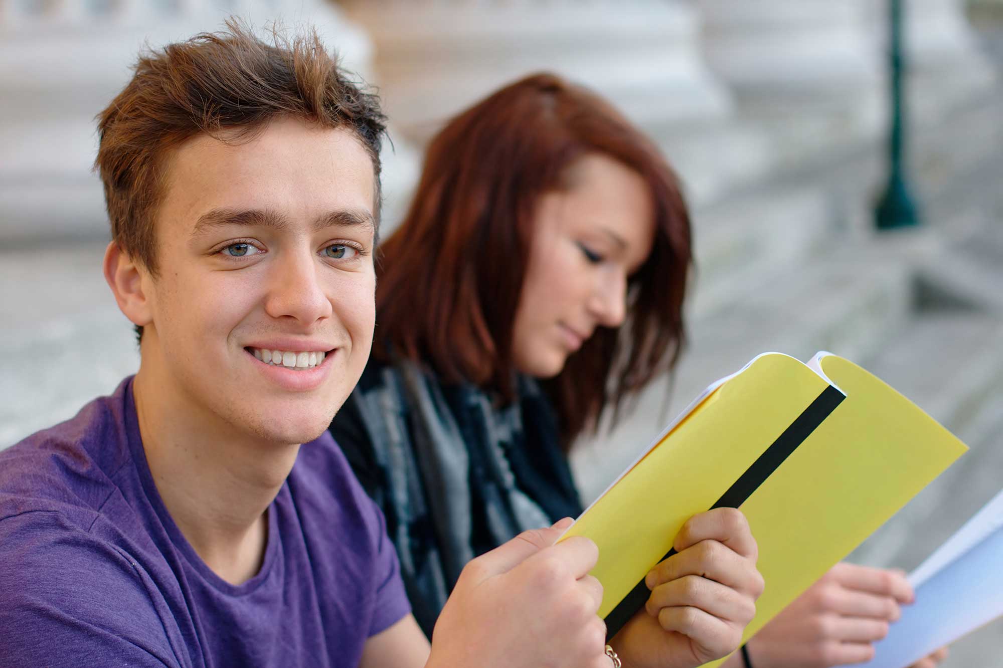 Jeunes lycéens assis, jeune homme souriant