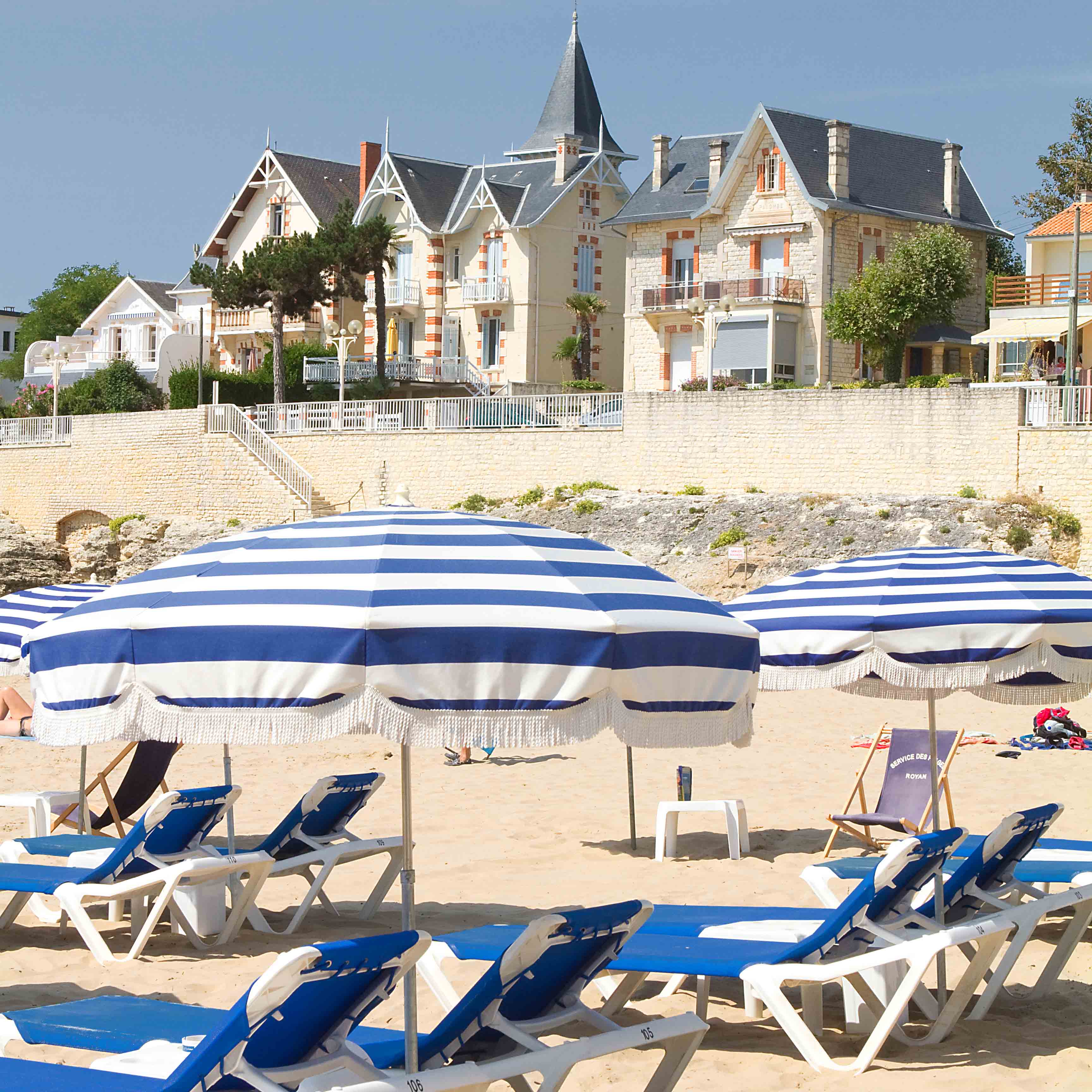 Plage de Royan avec des parasols à rayures bleues et blanches, en Nouvelle-Aquitaine