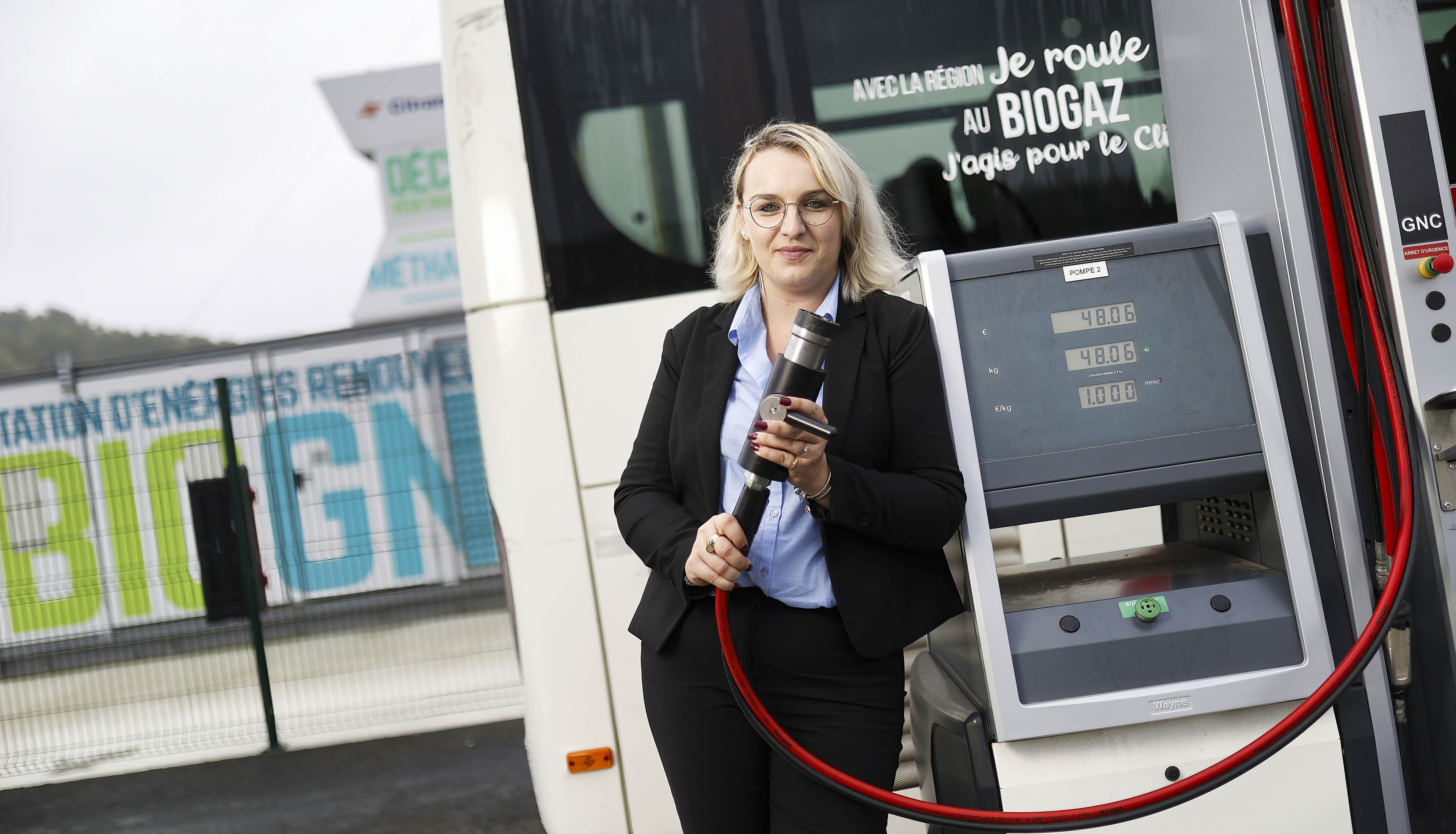 Femme de face tenant une pompe de recharge biogaz