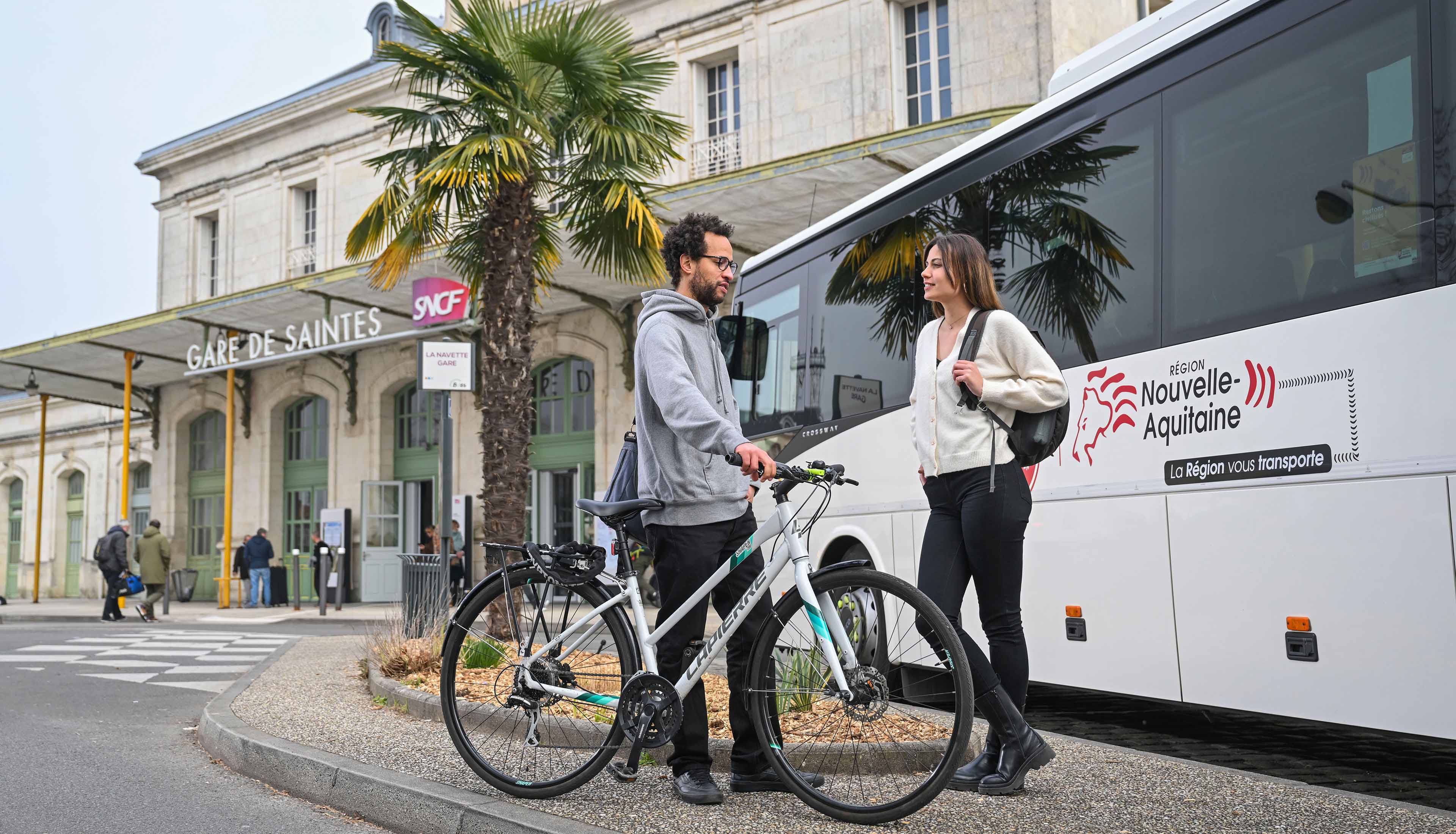 Des voyageurs devant la gare de Saintes