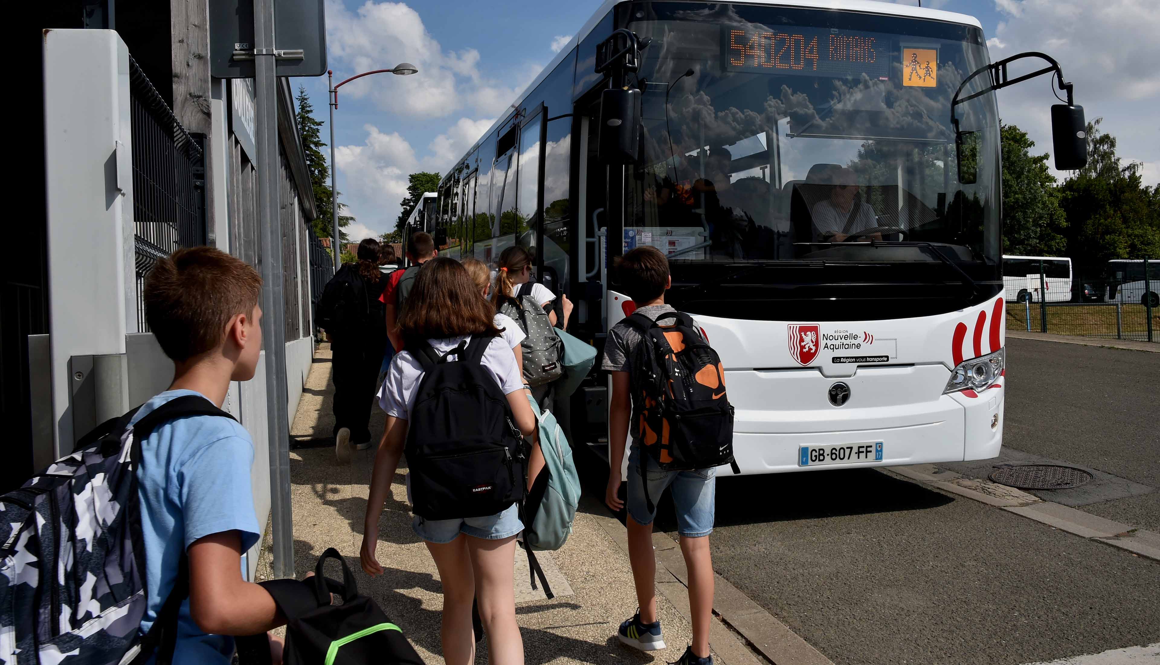 Elèves qui montent dans un car scolaire régional