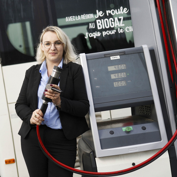 Femme de face tenant une pompe de recharge biogaz