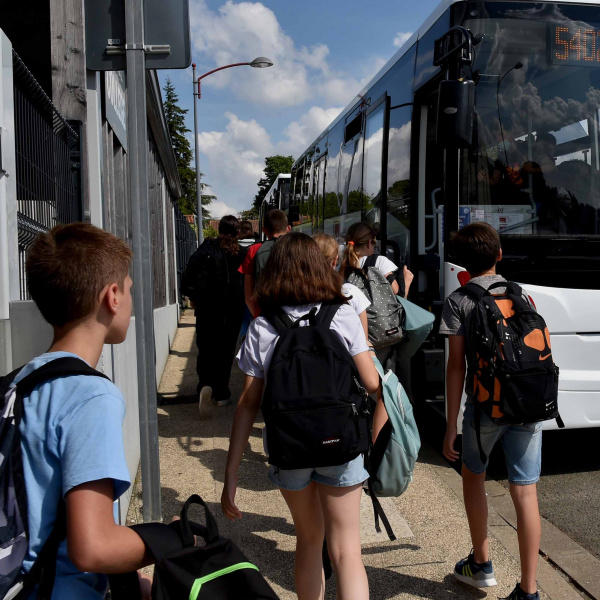 Elèves qui montent dans un car scolaire régional