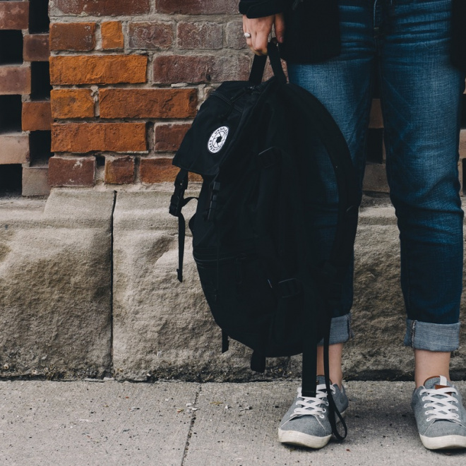 Jeune fille avec sac à dos à la main