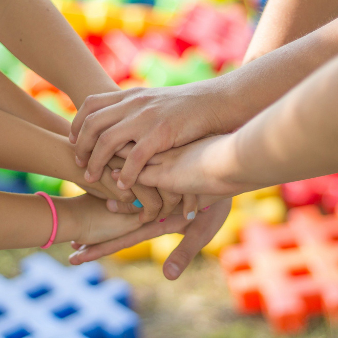 Mains de jeunes gens, superposées, signe de solidarité