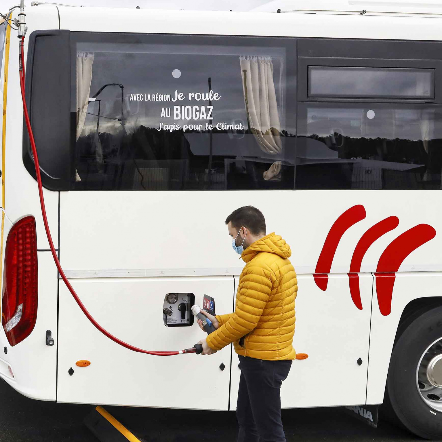 Personne remplissant un car au biogaz